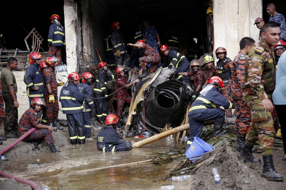 Bombeiros trabalham para remover os destroços de um prédio，<a href=